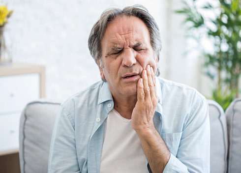 Older man holding jaw in pain before making appointment at Brush & Floss Dental Center in Stratford, CT