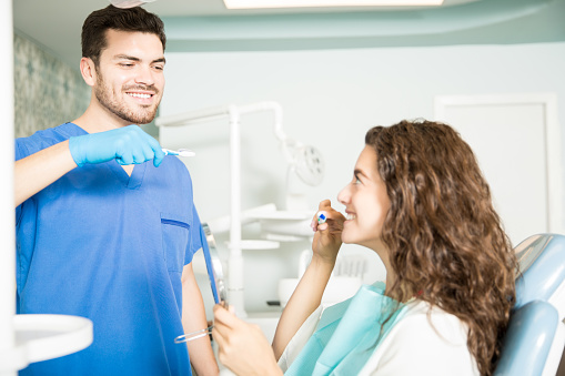 Image of a dental professional explaining to a patient, how to improve oral health, at Brush & Floss Dental Center in Stratford, CT.